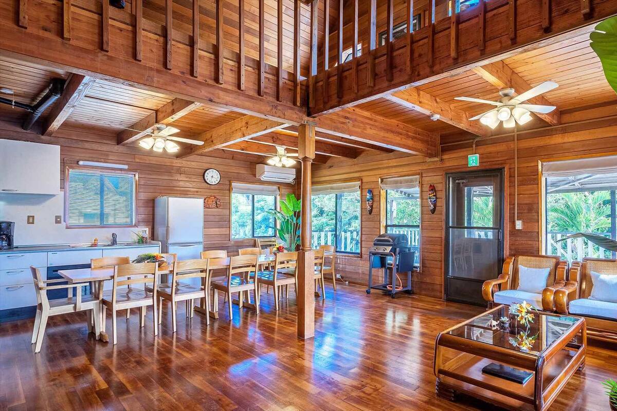 A spacious wooden interior with a dining area, kitchen, and seating area.
