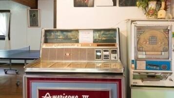 A vintage jukebox and a table tennis table in a room with framed pictures on the wall.