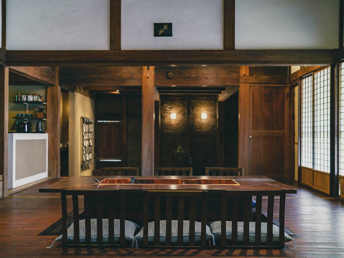 Una habitación tradicional japonesa con suelo de tatami, una mesa de madera baja y una puerta corredera.