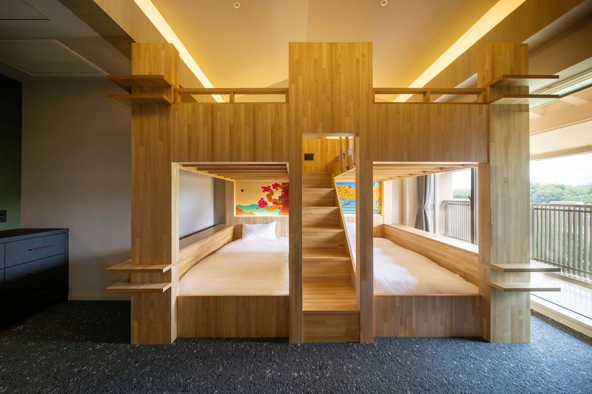 A room with a central staircase, wooden walls, and a window with a view.