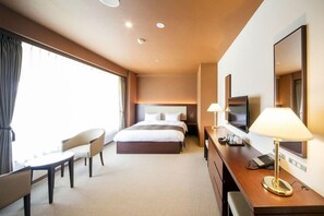 A hotel room with a bed, a desk, a chair, a TV, and a lamp. - Nesta Resort Kobe Royal Suite Villa (Miki)