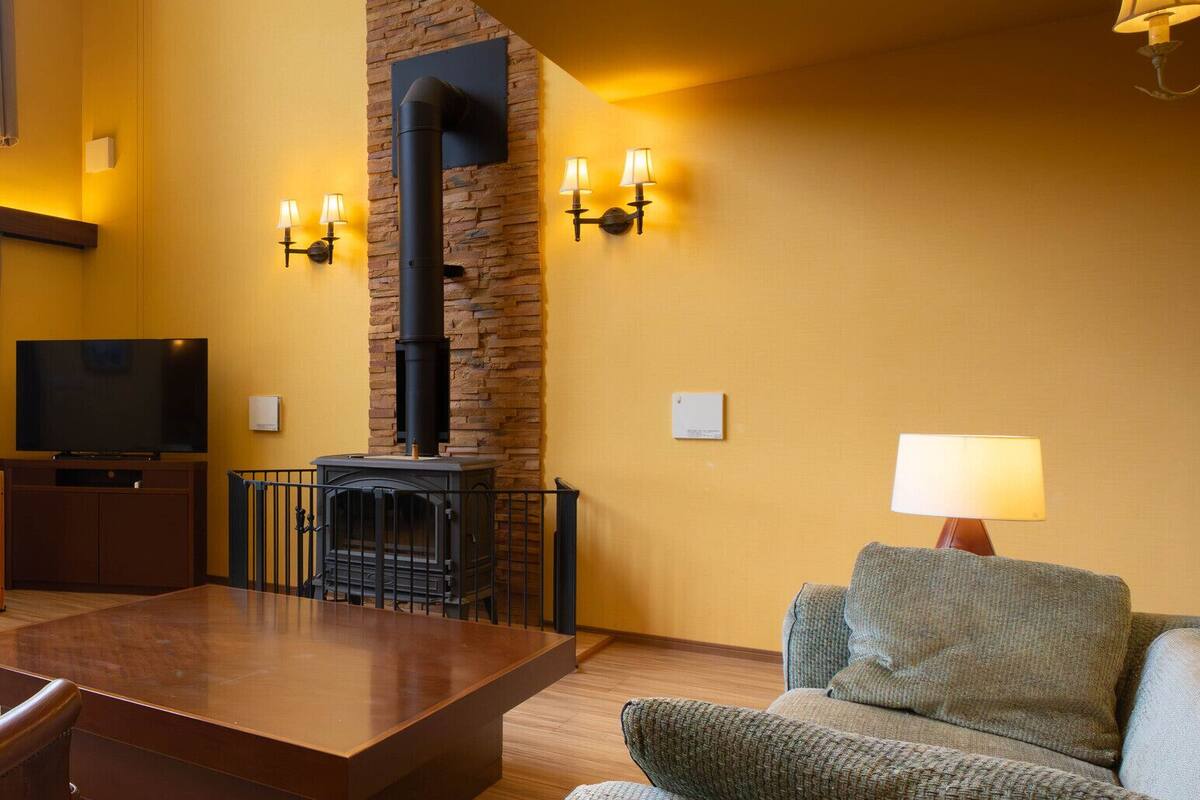A living room with a fireplace, a television, and a sofa.