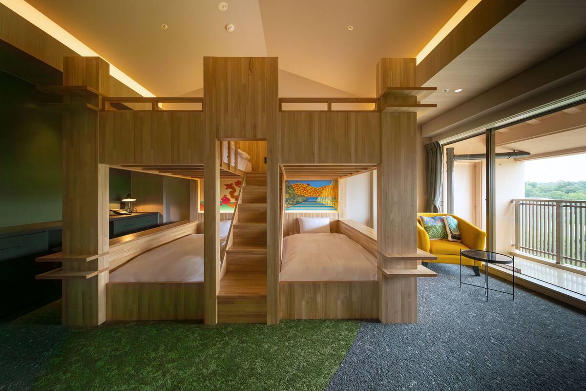 A modern interior with bunk beds, a desk, and a balcony with a view.