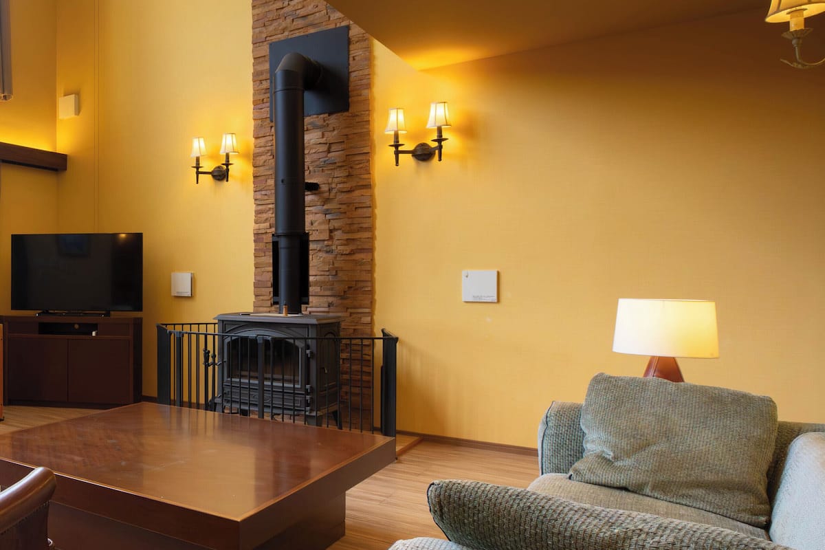 A living room with a fireplace, a television, and a sofa.