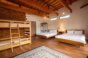 A room with two beds, a bunk bed, wooden flooring, and a ceiling with exposed beams. - Nesta Resort Kobe Royal Suite Villa (Miki)