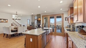 A spacious kitchen with wooden cabinets, granite countertops, and a large island. - Birch and Squirrel - Quiet Luxury, Near Great Camp & Downtown Banner Elk (Banner Elk)