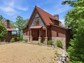 A two-story wooden house with a stone foundation, a red roof, and a gravel driveway. - Birch and Squirrel - Quiet Luxury, Near Great Camp & Downtown Banner Elk (Banner Elk)