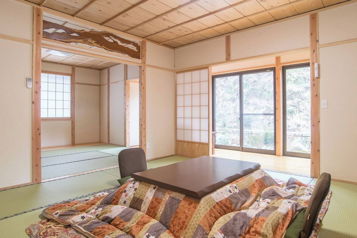 A traditional Japanese room with tatami flooring, a low table, and shoji screens.