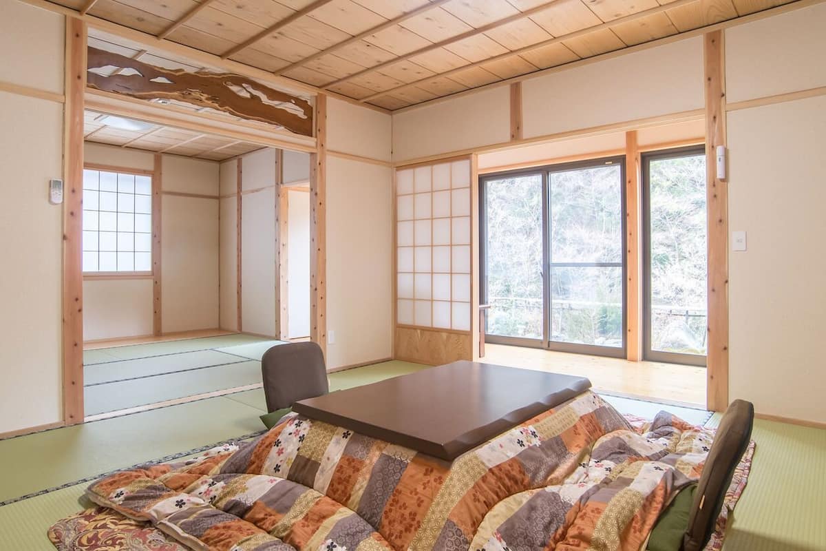 A traditional Japanese room with tatami flooring, a low table, and shoji screens.