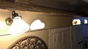 Um quarto com lareira de pedra, arco decorativo de metal e porta de madeira.