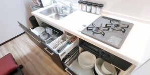 A compact kitchen with a stove, sink, and storage cabinets.