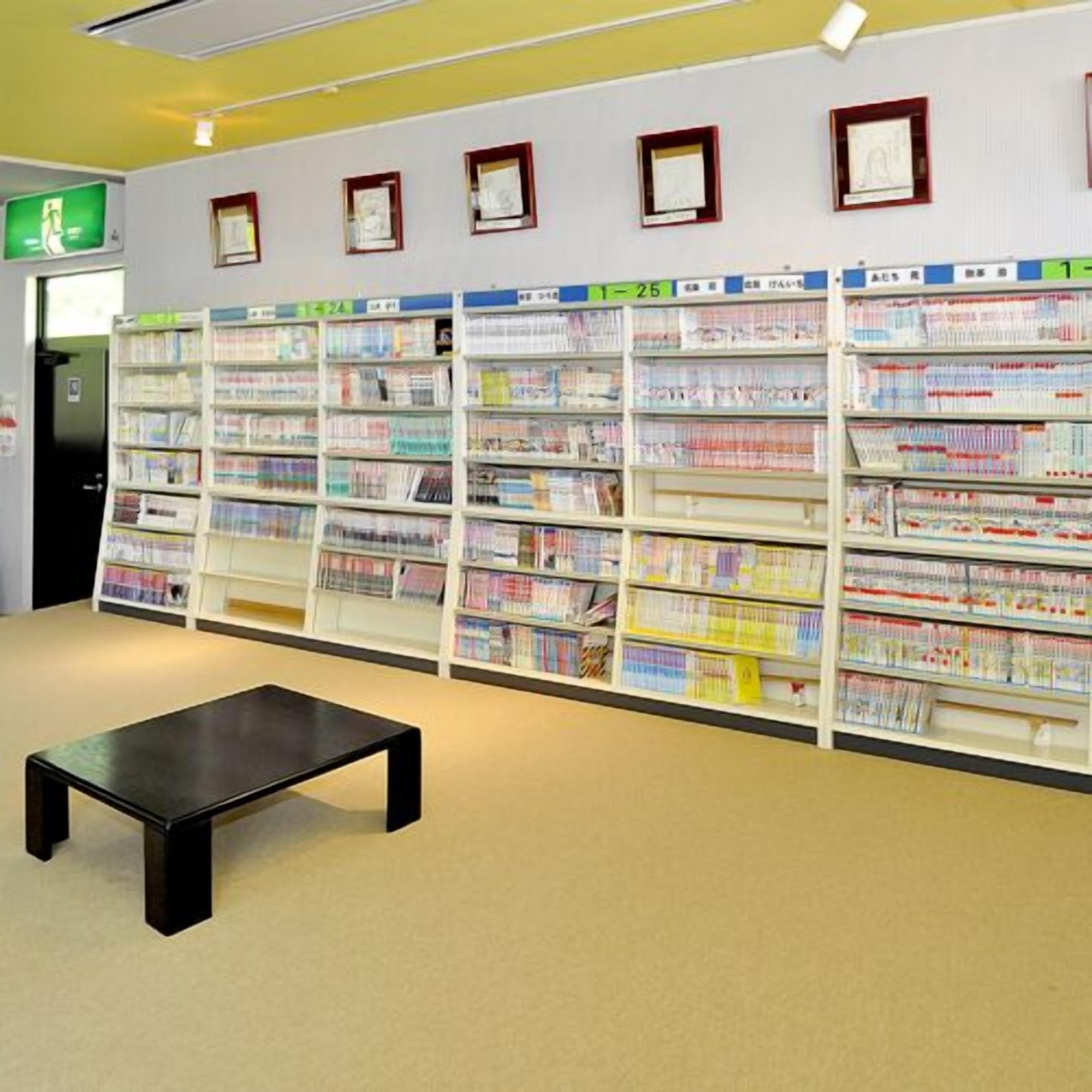 Eine Bibliothek mit Bücherregalen und einem schwarzen Tisch.