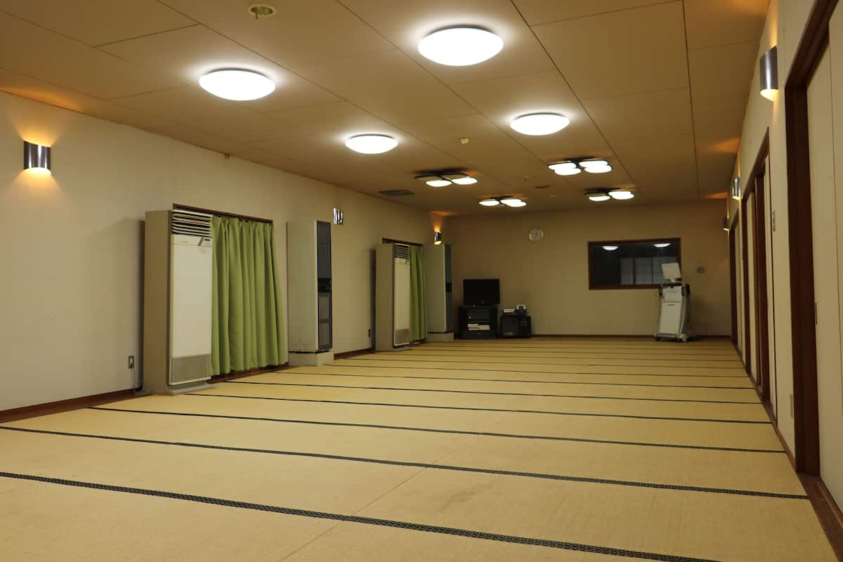 Ein Flur mit Tatami-Matten, einem Heizkörper, einer Uhr und einem Wagen.