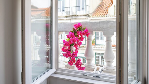 Ein Fenster mit Blick auf einen Balkon und eine weiße Balustrade.