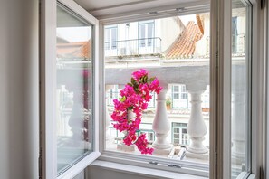 Une fenêtre donnant sur un balcon et une balustrade blanche.
