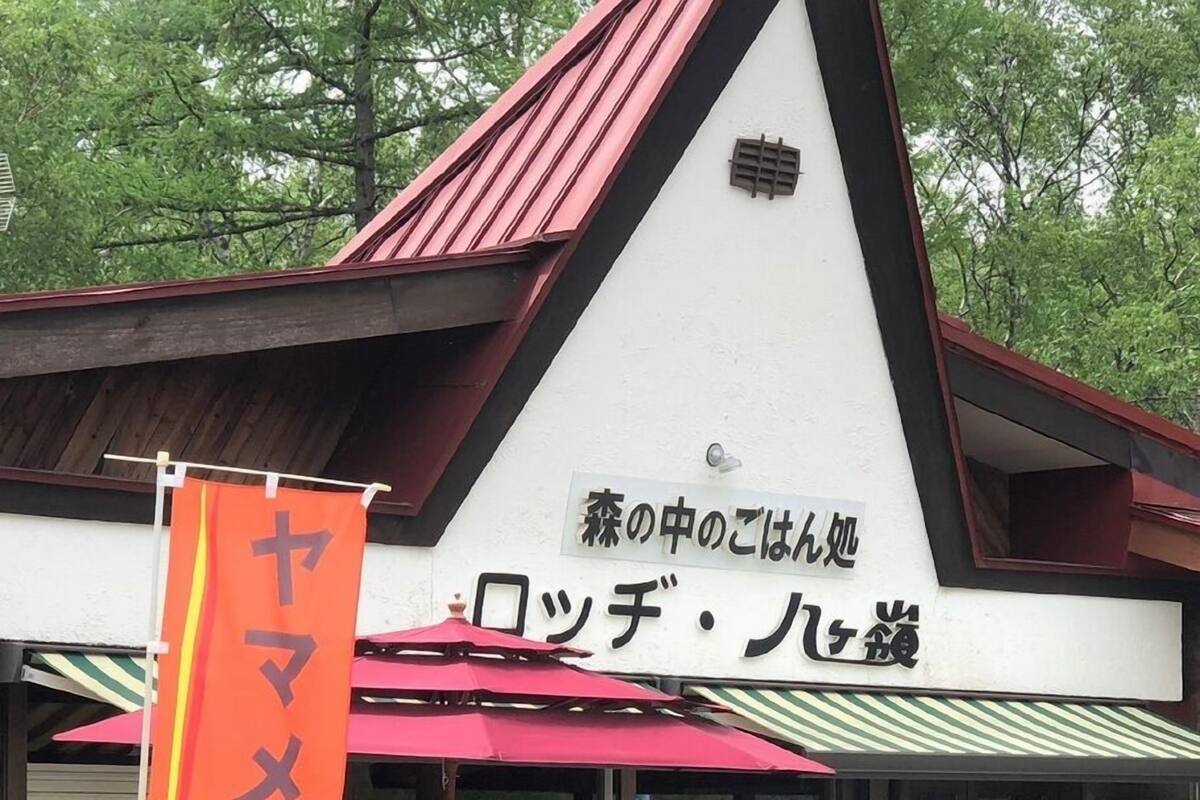 Um edifício com telhado vermelho e uma placa em japonês.
