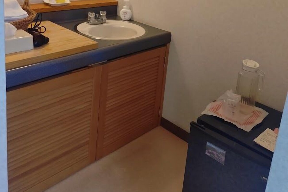 A bathroom with a sink, mirror, and wooden cabinets.