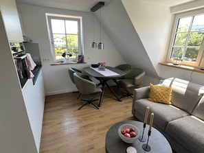 Eine moderne Loft-Wohnung mit Essbereich, einer Couch und einem runden Couchtisch.