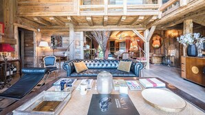 Ein geräumiges Blockhaus-Interieur mit Ledersofa, Essbereich und einer Erkerwohnung mit Blick.