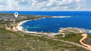 An aerial view of a coastal area with a beach, roads, and a dense green landscape. - The Surf Nook | Walk to Beach | Family Friendly (Gracetown)