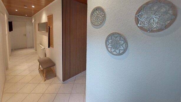 Ein Flur mit Holzboden, einer Bank und Wanddekoration.