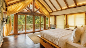 A spacious bedroom with a large bed, wooden ceiling beams, and a balcony with curtains. - Avana Holiday Experiences (Kalpetta)