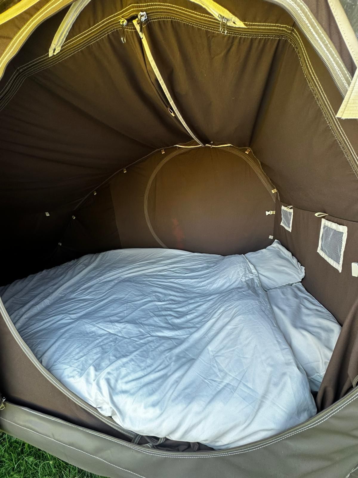 A tent with a sleeping area, including a bed and a pillow.
