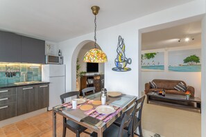 Eine moderne Küche mit Essbereich, einer Couch und einem Wandbild.