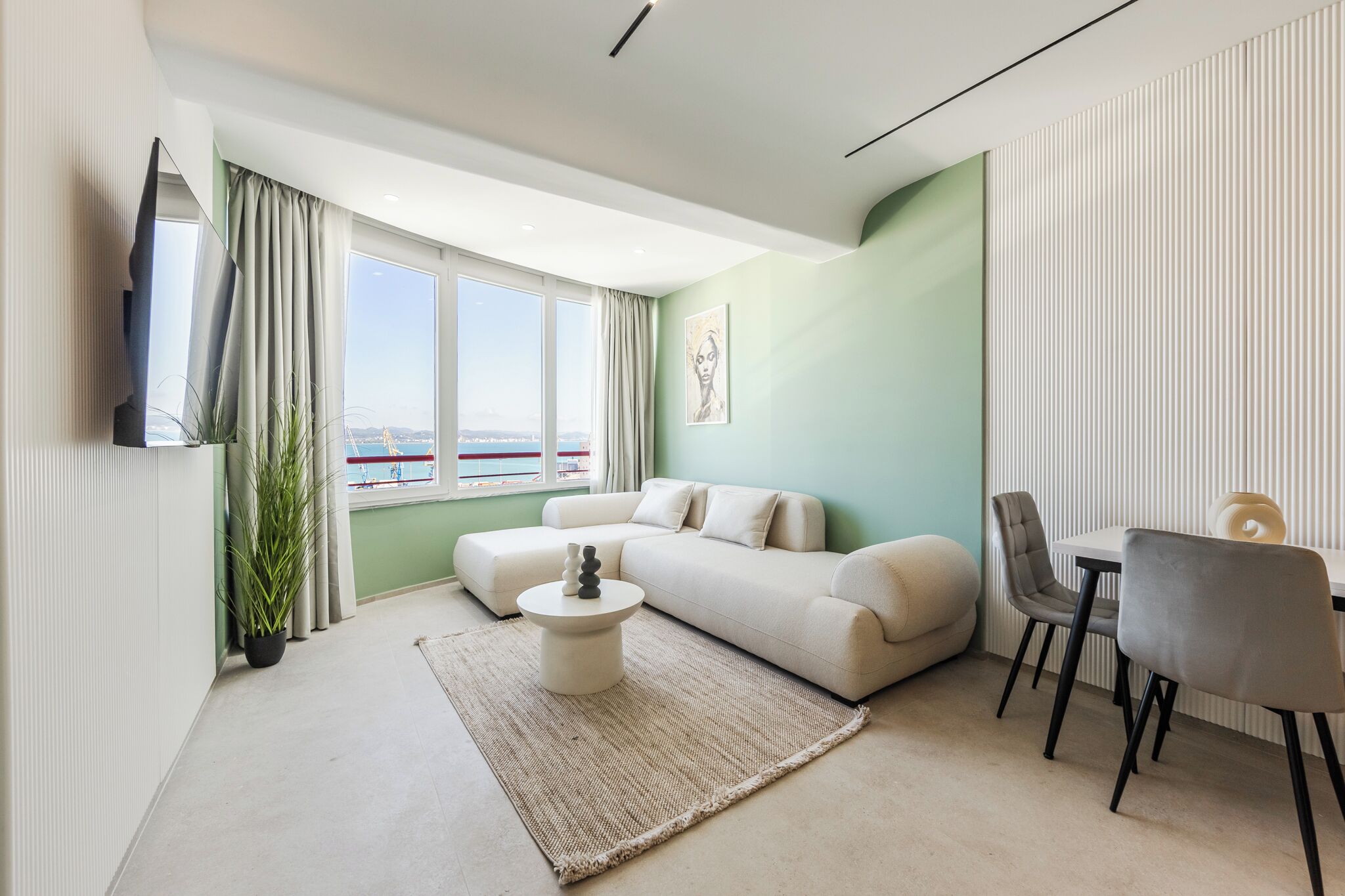 A modern living room with a sofa, coffee table, and dining area.