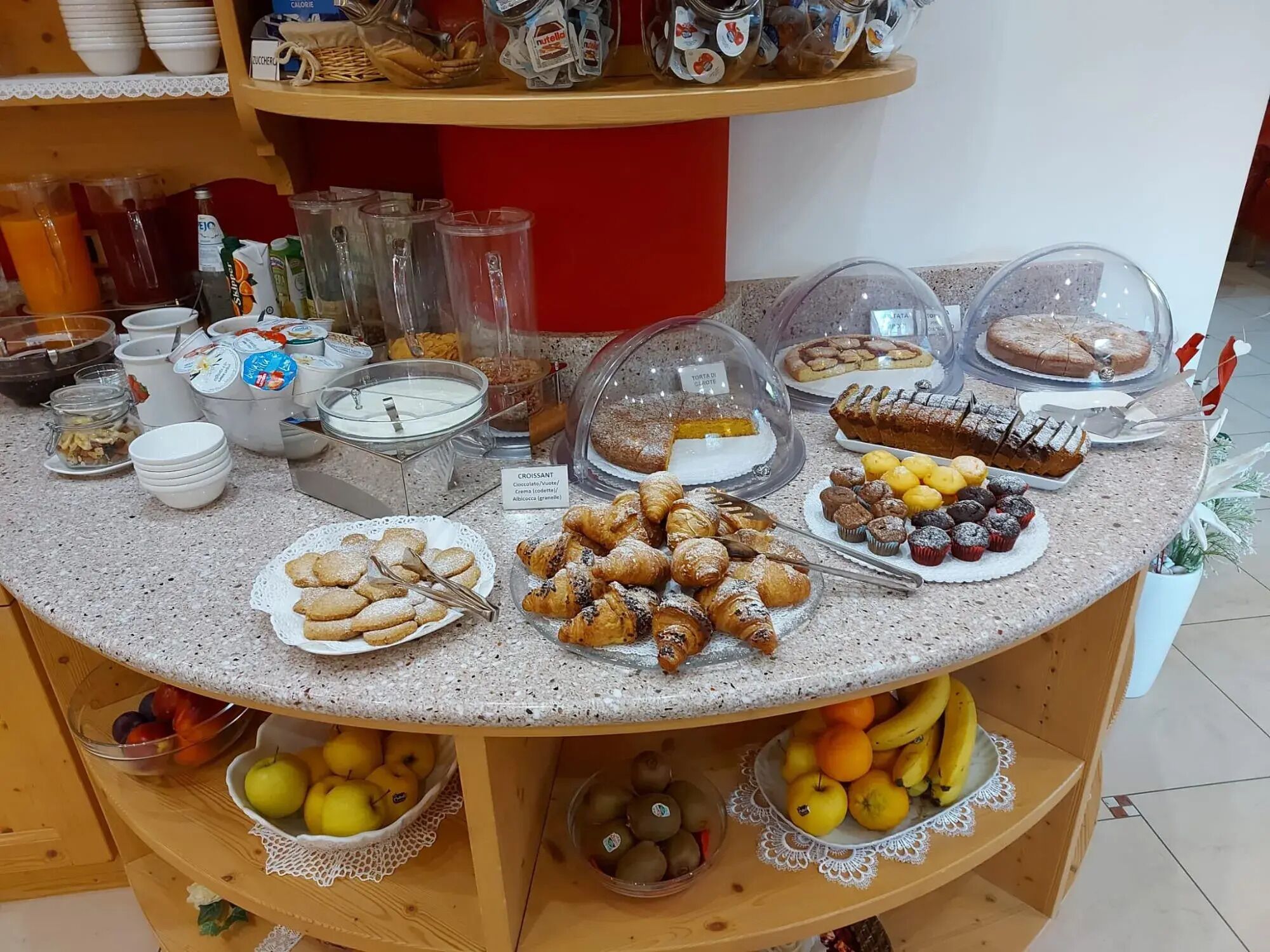 Ein Buffet mit verschiedenen Speisen, darunter Gebäck, Kuchen und Früchte.