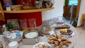 A buffet with various food items, including pastries, desserts, and condiments. - Hotel Garnì Arnica (Molveno)