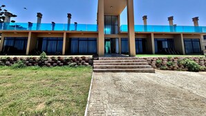 A modern hotel with a central entrance, multiple balconies, and a clear sky. - WAVES ocean front King Shaka Airport (Desainager)