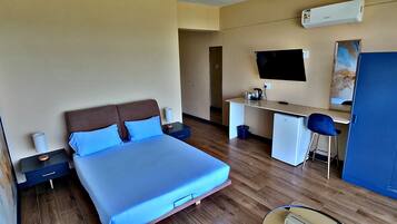 A bedroom with a bed, desk, chair, and a wardrobe.