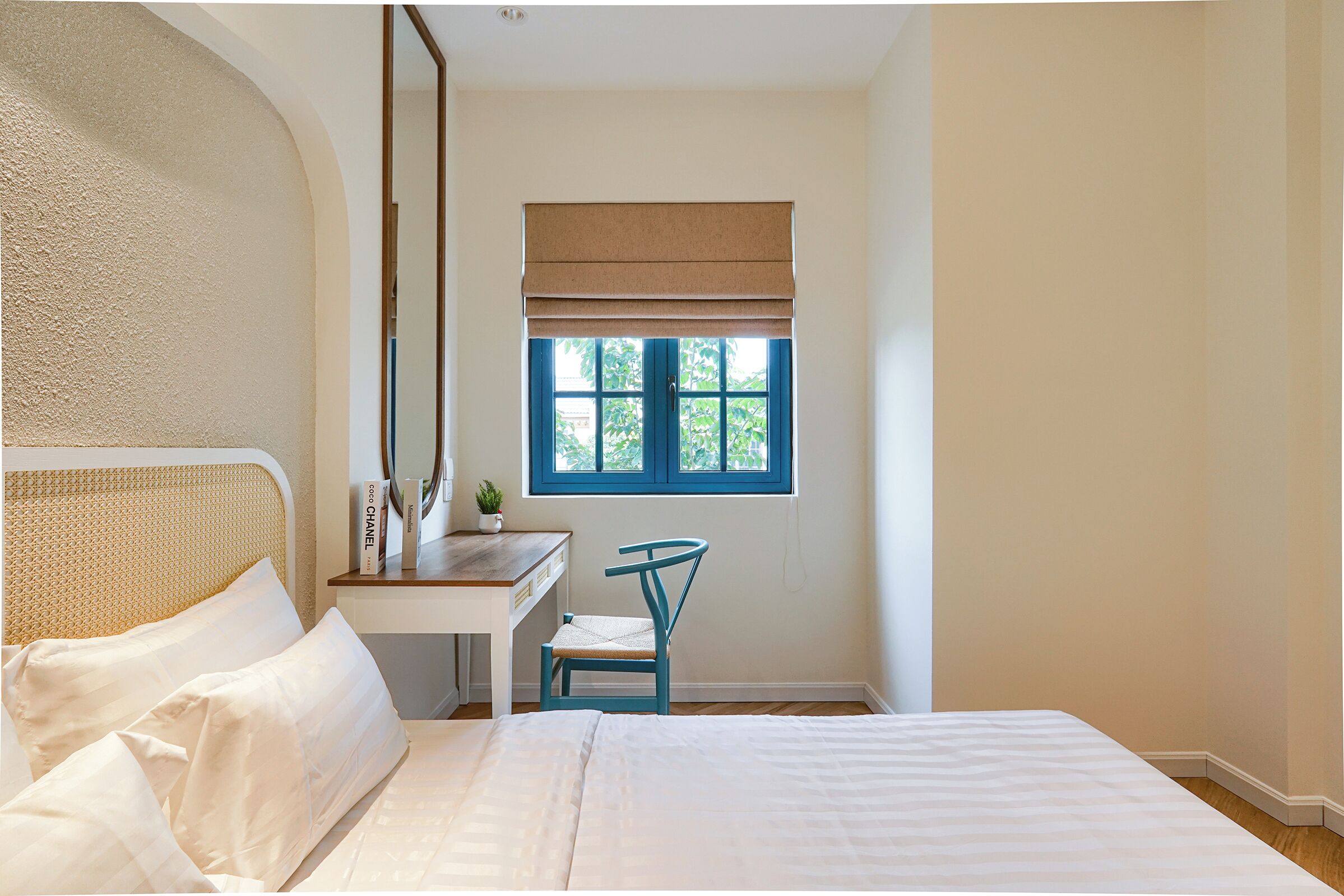A bedroom with a bed, a desk, and a chair.