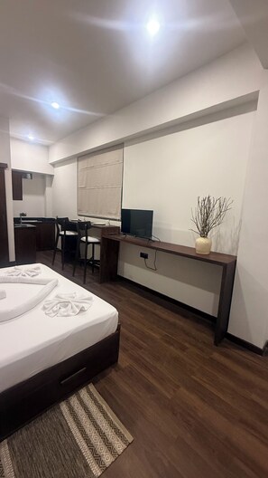 Ein modernes Hotelzimmer mit Bett, Schreibtisch und Stuhl.