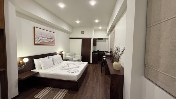 Ein modernes Hotelzimmer mit einem großen Bett, einem Schreibtisch und einem Badezimmer.