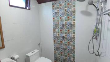 Un baño con ducha, inodoro y lavamanos.