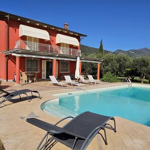 A pool area with lounge chairs and a building with a balcony. - VILLA BICE- PRIVATE POOL - TUSCANY - Versilia near the beach (Strettoia)
