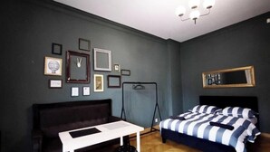 A bedroom with a bed, a desk, a chair, and a hanging light fixture. - Fantastic Inn Kraków - Słowackiego (Kraków)