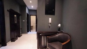 A hallway with a dark wall, a wooden bench, and a door at the end. - Fantastic Inn Kraków - Słowackiego (Kraków)
