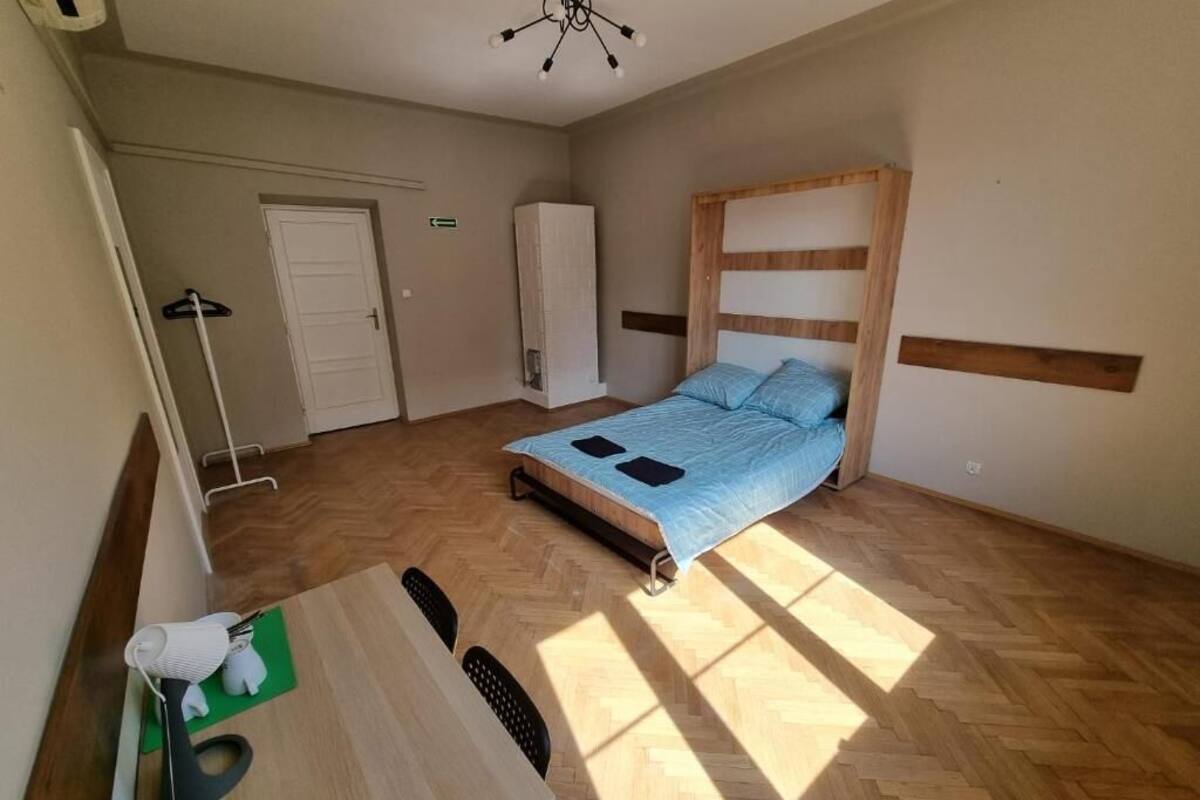 A bedroom with a bed, a desk, and a chair.