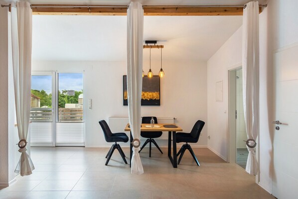 A dining area with a table, chairs, and a pendant light. - Apartment 'Ferienwohnung 2' in Northeim – Komfort für 2 Gäste (Northeim)