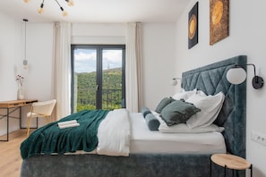 A bedroom with a bed, a desk, a chair, and a view of greenery outside. - Relaxed Family Villa in Naklice (Naklice)