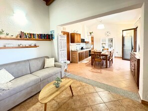 A living room with a sofa, coffee table, and bookshelves. - La Dolce Villa Tertenia – Mediterranean Elegance by the Sea (Tertenia)