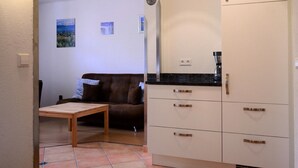 A compact living space with a kitchenette, a dining area, and a sofa. - Dauth Apartment in the Heart of the Village (Kressbronn)