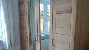 A room with a wooden wardrobe, a radiator, and a window with curtains. - Dauth Apartment in the Heart of the Village (Kressbronn)
