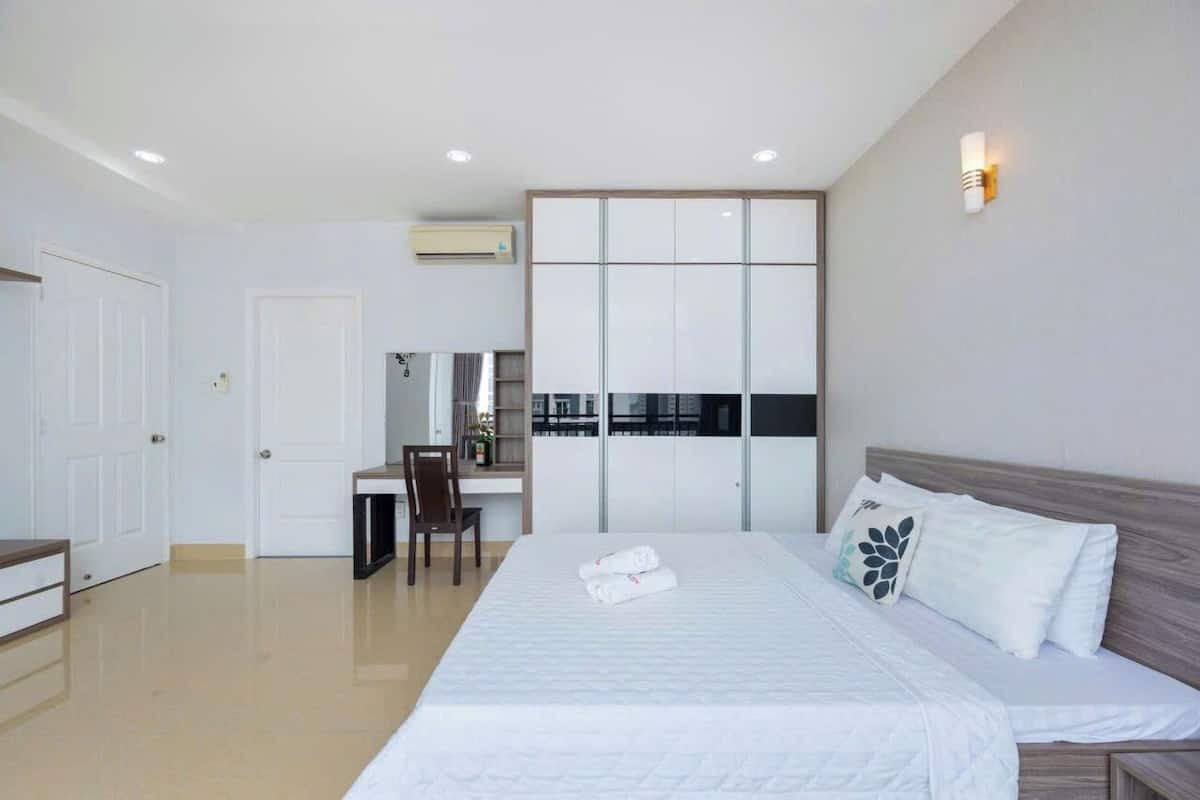 Une chambre d’hôtel moderne, dotée d’un grand lit, d’un bureau et d’une armoire.