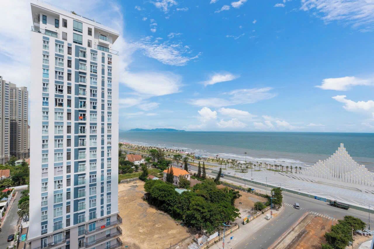 Um hotel alto com vista para a praia e o oceano.