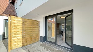 Il s’agit d’une propriété résidentielle dotée d’une clôture en bois, d’une porte-fenêtre coulissante et d’une terrasse carrelée.
