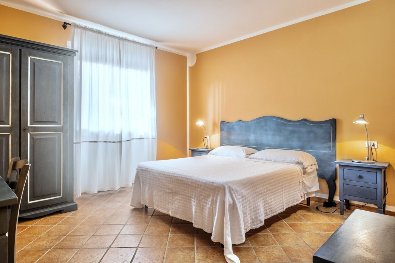 Une chambre à coucher comprenant un lit, des tables de chevet, un bureau et une armoire.